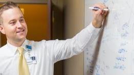 校友帕特里克·哈林斯基(Patrick Halinsky)在当地一家医院用一块白板绘制流程图.